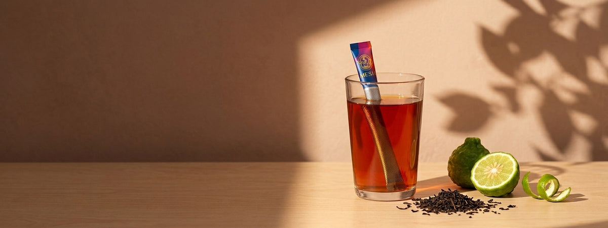 Siyah çay hero afişi — yayılmış tam yaprak ve bergamot kabuğu